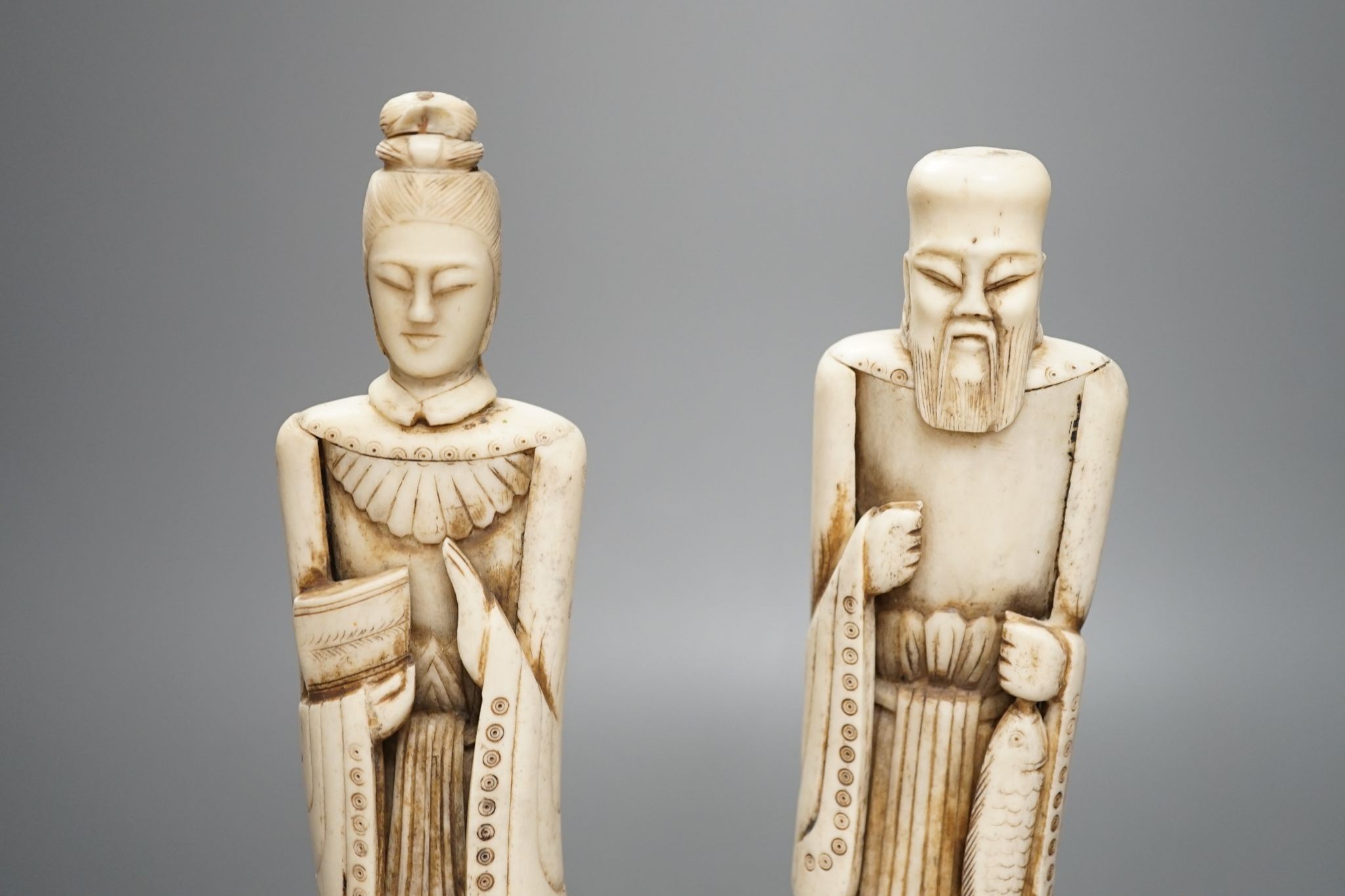 A pair of Chinese carved bone figures, Tallest 27 cms high.